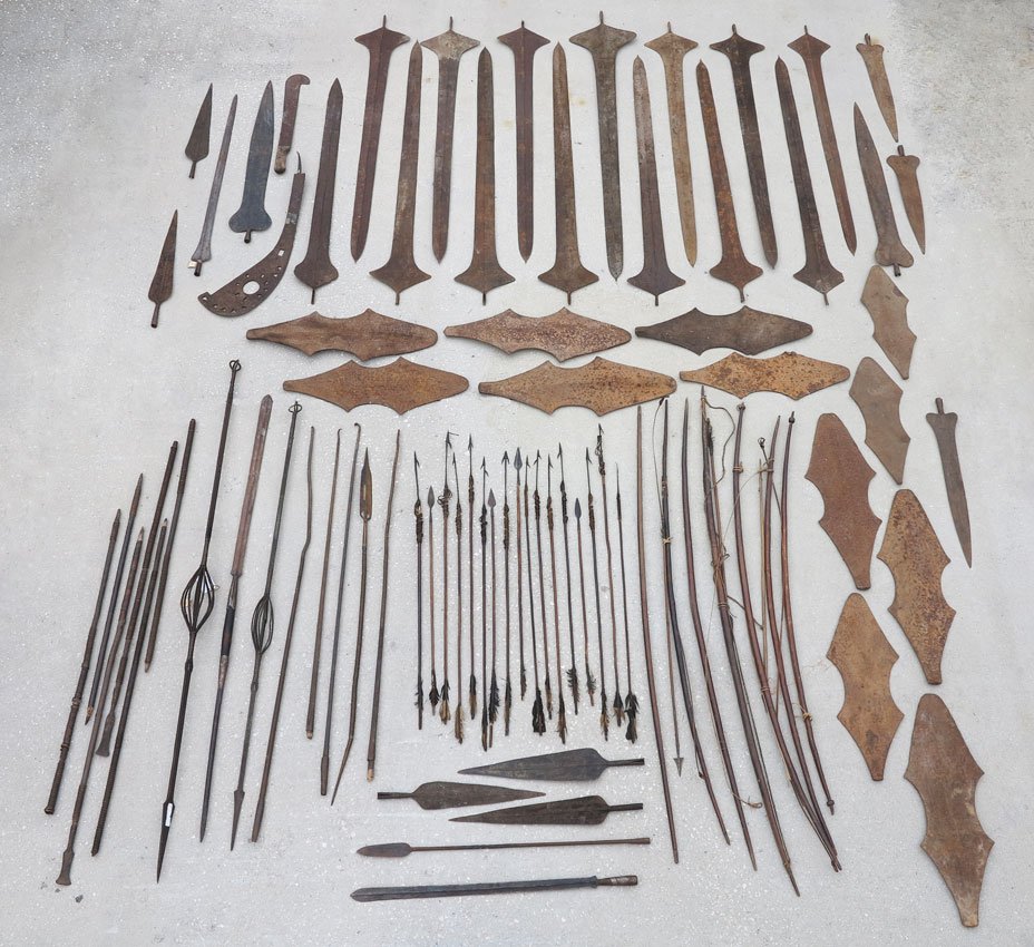 CARVED AFRICAN SWORDS, SPEARS, ARROWS, ETC.: CARVED AFRICAN SWORDS, 15 SPEARS, 17 ARROWS, 25 SPEARHEADS, 14 LONG SPEAR BLADES, AND 7 BOWS: Longest spear is 6ft.