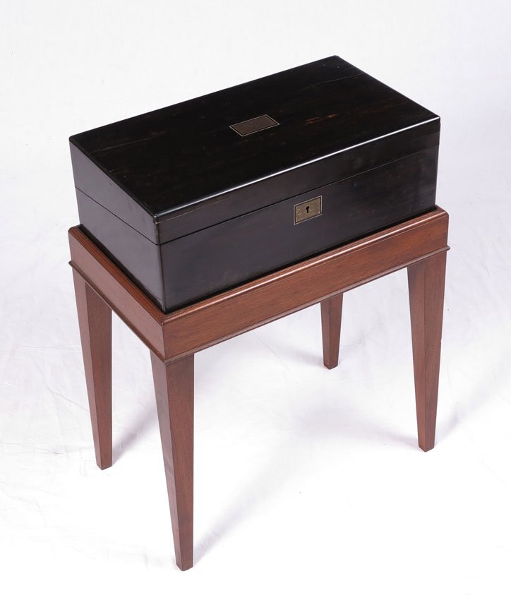 EBONIZED LAP DESK ON STAND: EBONIZED LAP DESK ON STAND: Fitted interior with red writing surface, pen tray, ink bottle, stamp box and storage. Key locking (key included). The box measures 6 1/2" x 18" x 10". On the stand they ar