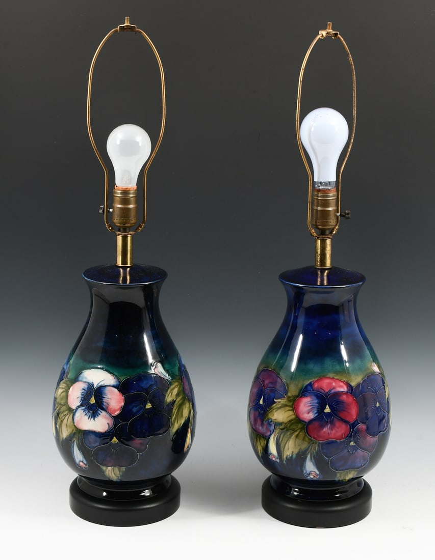 PAIR OF MOORCROFT "ORCHID" ART POTTERY LAMPS: PAIR OF MOORCROFT "ORCHID" ART POTTERY LAMPS: A pair of baluster form Moorcroft blue ground, Orchid motif table lamps. Both mounted on an Ebonized wood base. Approx. 27.5" h x 8" Dia.