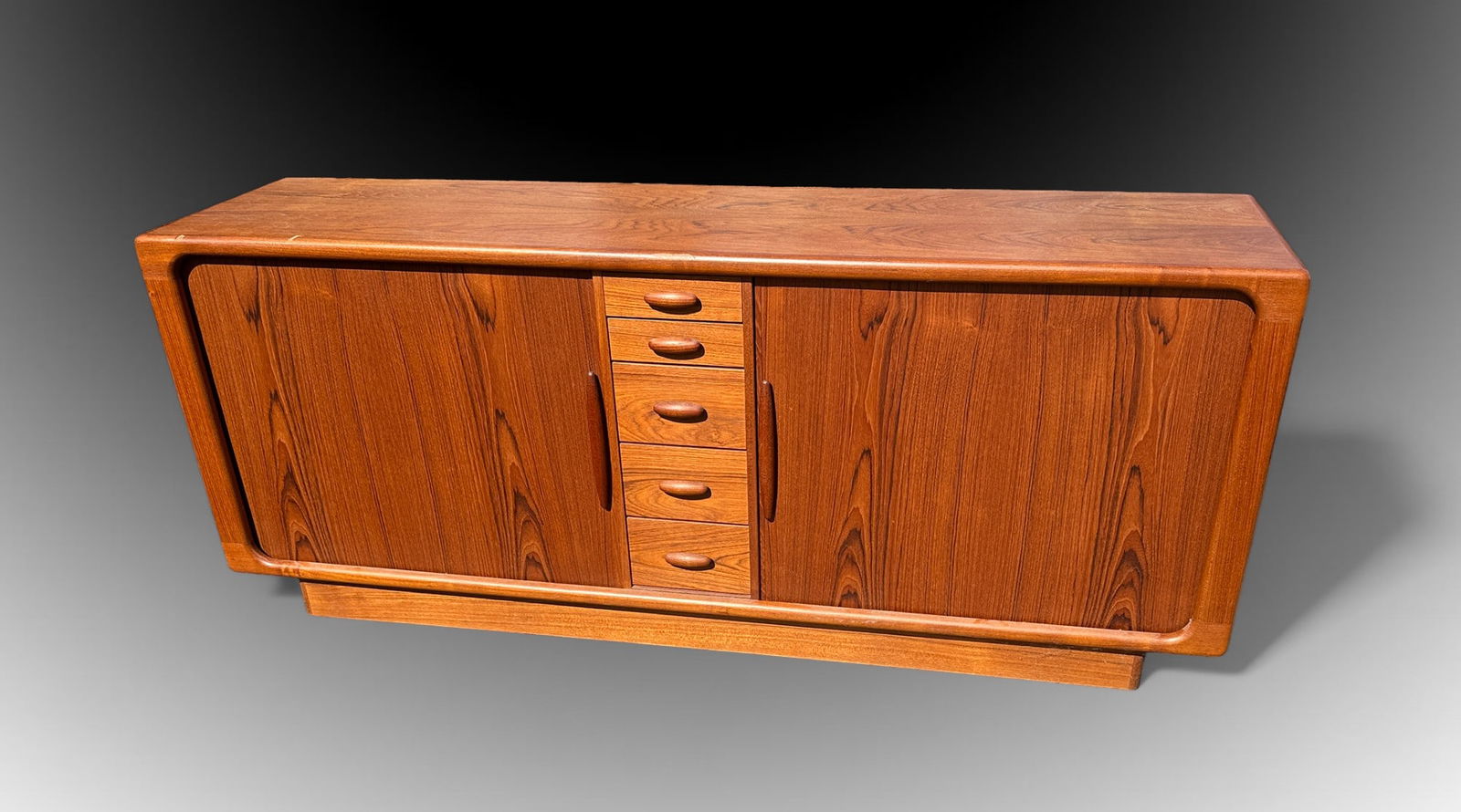 TEAK TAMBOUR DOOR CREDENZA BY DYRLUND: TEAK TAMBOUR DOOR CREDENZA BY DYRLUND: Danish Modern Teak Credenza with 5- central drawers, flanked by Tambour doors. Left Door opens to reveal a single drawer over compartment. Right door houses 4- d