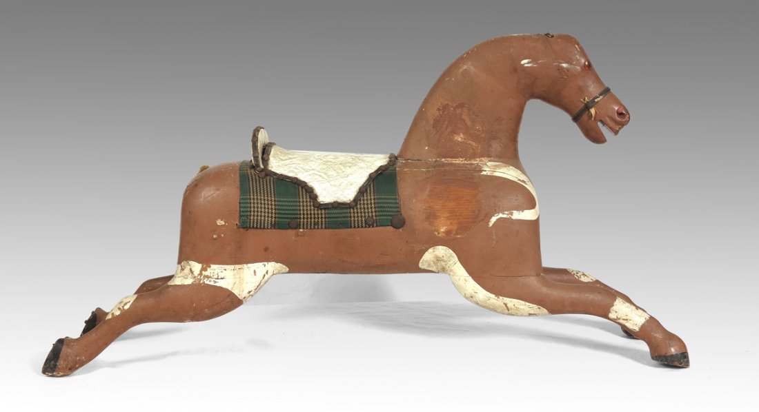 ANTIQUE CHILD'S CAROUSEL HORSE: ANTIQUE CHILD'S CAROUSEL HORSE: Primitive carved and painted wood stationary horse, childs size. Tacked vinyl seat. Measures 15 1/2" h. x 45" x 9 1/2".