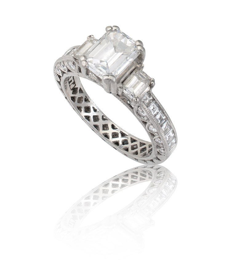 TACORI PLATINUM 2.91 CTW DIAMOND RING GIA CERT: TACORI PLATINUM 2.91 CTW DIAMOND RING: Platinum engagement ring centers an approx. 1.53 Ct. GIA certified emerald cut diamond, rated VVS1 in clarity and E color. An additional 2 emerald cut, 12 straig