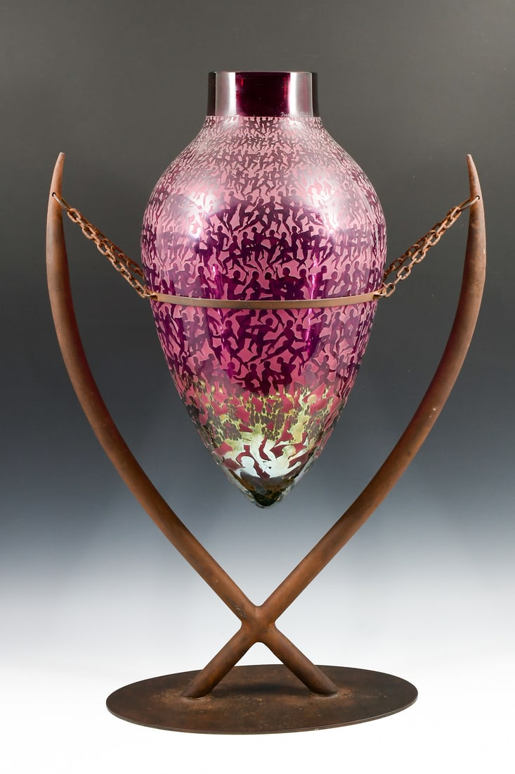 DUNCAN MCCLELLAN ART GLASS VASE: McCLELLAN, Duncan, (American, b. 1955): Monumental art glass vase, Etched and sculpted Amphora form vase, of the "Men A Morphis" pattern. Resting in a metal stand. Vase Approx. 20" h x 11" dia. Overal