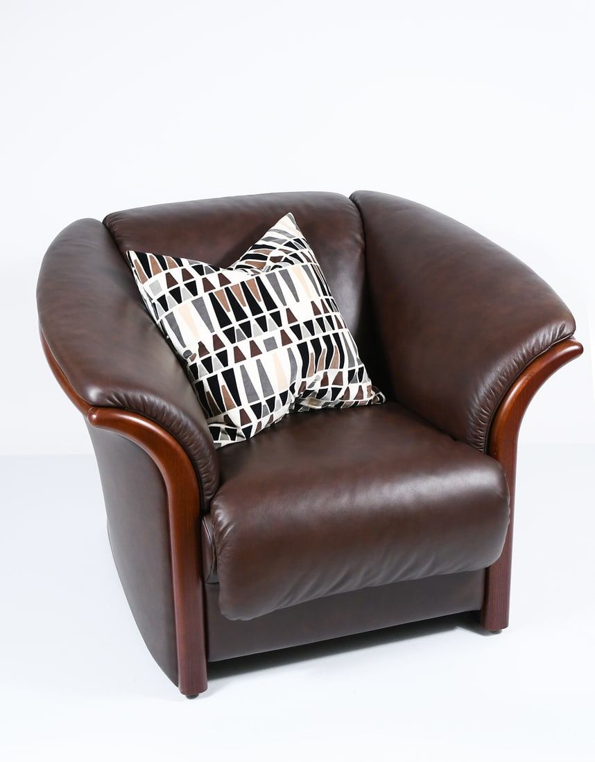 EKORNES LEATHER ARMCHAIR/LOUNGE CHAIR: EKORNES LEATHER ARMCHAIR/LOUNGE CHAIR: Flared arm Ekornes Club / Lounge chair in Brown Leather. Metal tag at lower left side. Approx. 30.5" h x 40.5" w x 35" d.