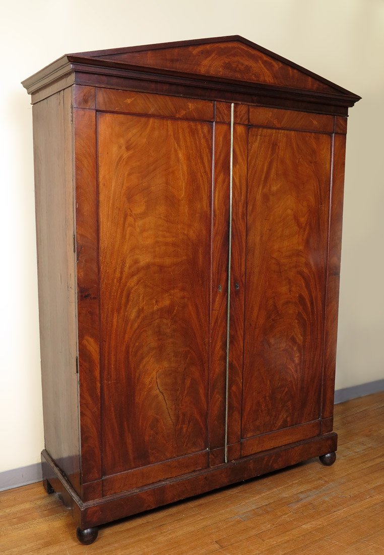 FRENCH LINEN PRESS, 1820: EARLY 19TH CENTURY MAHOGANY FRENCH LINEN PRESS: Crotch mahogany, architectural crest over 2 doors. Doors open to reveal 4 sliding shelves over 2 half drawers over full length drawer. 85" h. x 59 1/2" 