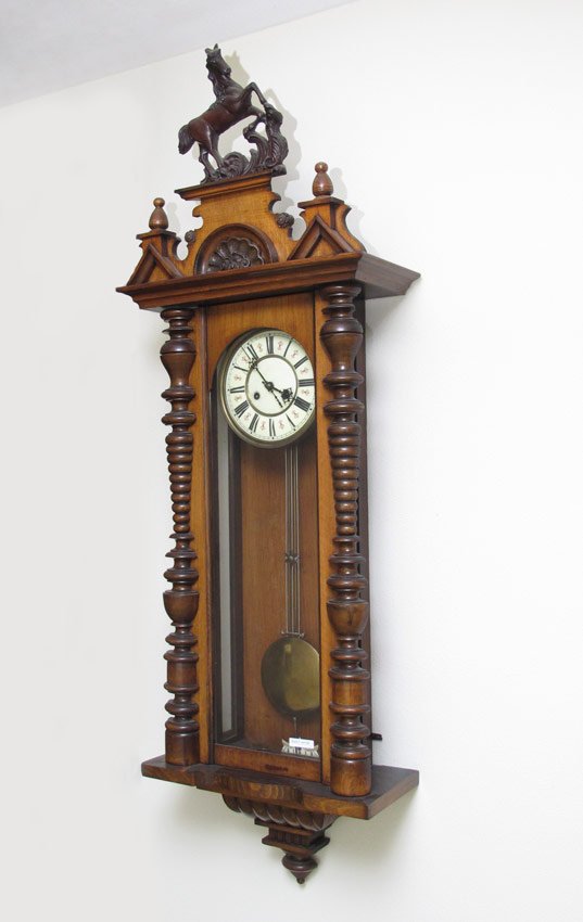 LARGE CARVED GERMAN REGULATOR WALL CLOCK: LARGE CARVED GERMAN REGULATOR WALL CLOCK: Architectural crest with carved horse finial. Walnut case with applied decoration. Porcelain dial with Arabic numerals, time and strike movement. Pendulum in 