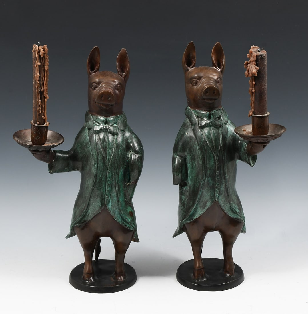 CONTINENTAL BRONZE PIG BUTLER CANDLESTICKS: CONTINENTAL BRONZE PIG BUTLER CANDLESTICKS: Pair of patinated cast bronze candlestick holders in the form of Pig Butlers. Circa 1930's. Approx. 16" h x 8.125" w x 4.5" d.
