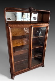 OAK BOOKCASE WITH BONNET TOP AND LION'S HEAD