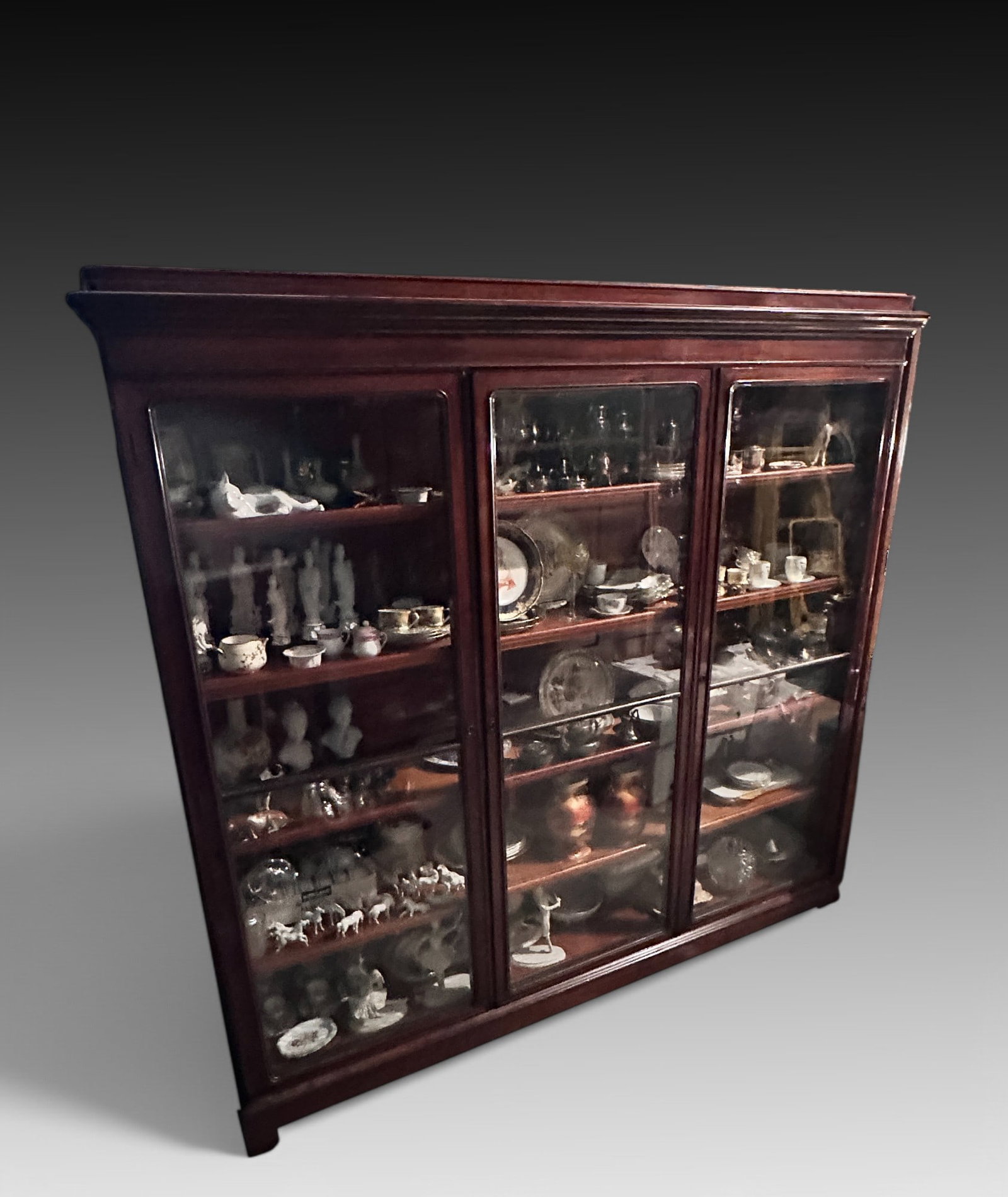 LARGE ANTIQUE 3-DOOR BOOKCASE: LARGE ANTIQUE 3-DOOR BOOKCASE: Hefty wide bookcase/display cabinet with three hinged glass doors. Measures 73.75” (h) x 73 (w) x 19” (d). Provenance: Albert and Carmen Bombach Estate, Old 