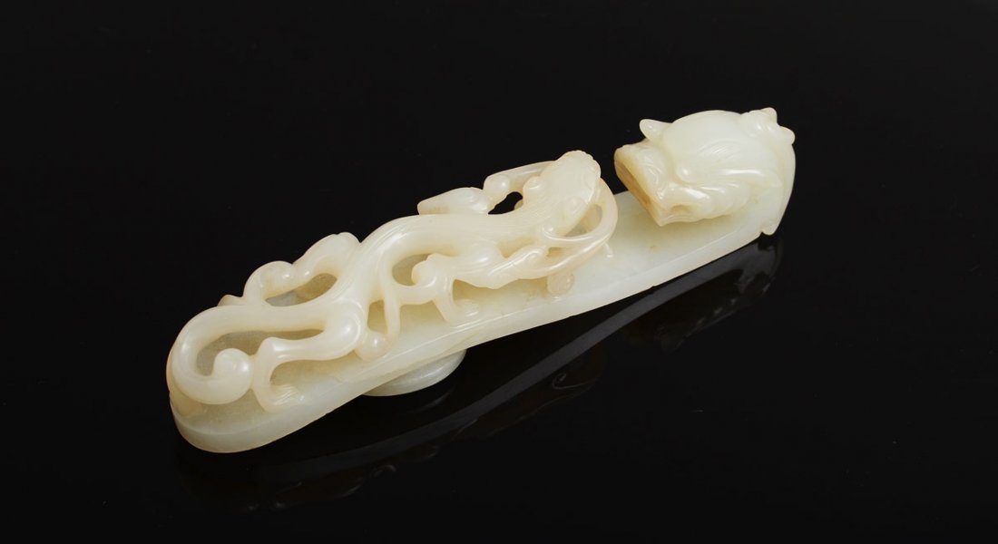 CHINESE WHITE JADE DRAGON FORM BELT HOOK: CHINESE WHITE JADE DRAGON FORM BELT HOOK: Single block carved in scepter form, dragon head hook and full body serpent decoration, 5 1/8'' long.