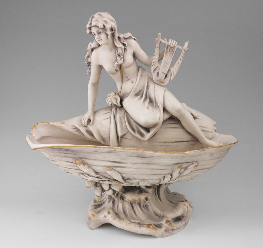 ROYAL DUX NUDE WOMAN ON SHELL COMPOTE: ROYAL DUX NUDE WOMAN ON SHELL COMPOTE: Semi nude woman with lyre seated on a seashell with crashing waves base. Royal Dux Bohemia ''E'' mark, dates from 1900-1918, impressed 2828 and 28 on base. 10 1/