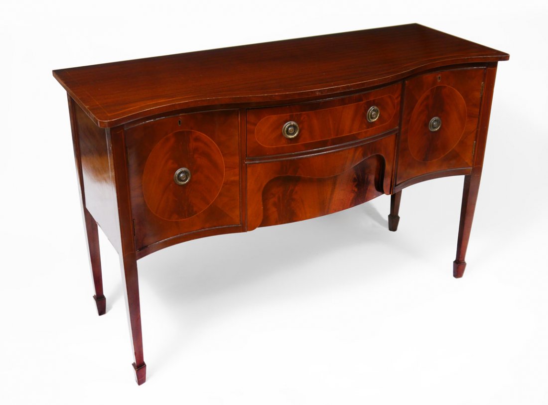 STRING INLAY MAHOGANY SIDEBOARD CREDENZA: SHERATON STYLE STRING INLAY MAHOGANY SIDEBOARD CREDENZA: Serpentine front and top with string inlay accents. 2 central drawers surmounted by door on either side. Tapered legs. 36 1/4" x 56 1/4" x 20 1