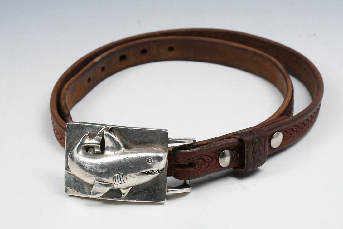 STERLING KIESELSTEIN-CORD SHARK BELT BUCKLE: STERLING KIESELSTEIN-CORD SHARK BELT BUCKLE: Comprised of one shark buckle crafted of sterling. Together with a 1" wide leather belt. Buckle is signed B. Kieselstein-Corg 1998 "925: 192. Shark buckle: