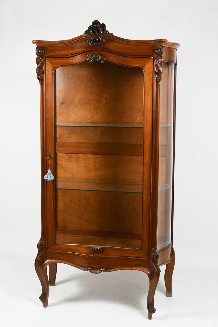 EARLY 20TH-CENTURY CURVED GLASS VITRINE: EARLY 20TH-CENTURY CURVED GLASS VITRINE: Carved Display Cabinet with curved glass front & sides, having an overall scrolled foliate design. Raised on Cabriole legs with Whorl feet. Approx. 72" h x 36.