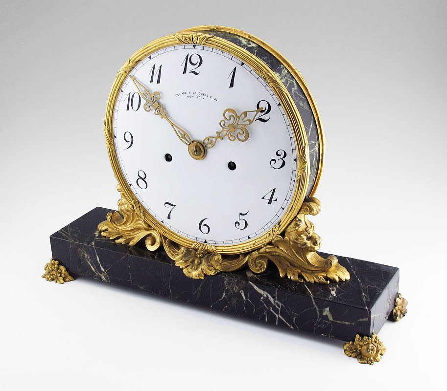 E.F.CALDWELL ORMOLU & MARBLE MANTLE CLOCK: E.F.CALDWELL ORMOLU & MARBLE MANTLE CLOCK: Ormolu mounted with marble ring and base, marked Edward F. Caldwell & Co., New York on porcelain face with Arabic numerals. Key wind time only movement. Key