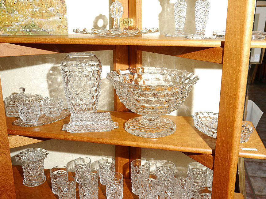 82 pc. FOSTORIA GLASSWARE IN THE AMERICAN PATTERN: FOSTORIA GLASSWARE IN THE AMERICAN PATTERN: Approx. 82 pieces to include the 12" pedestal punch bowl, 10" vase, covered butter, ice bucket, vase with flower frog, charger (14 1/4" dia.), 10 plates (9"