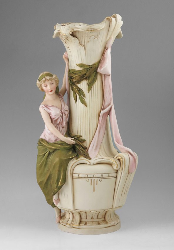 ROYAL DUX FIGURAL MAIDEN VASE: ROYAL DUX FIGURAL MAIDEN VASE: Figural maiden with swags. Circa 1900-1918 mark, impressed 1469, underglaze signature. 17" h. x 9".