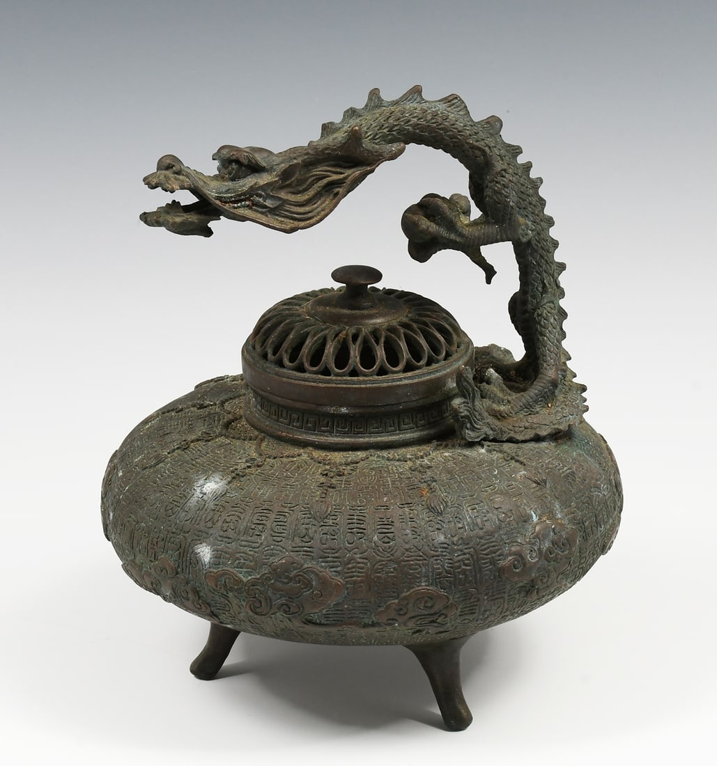 CHINESE BRONZE DRAGON CENSER: CHINESE BRONZE DRAGON CENSER: Lidded Chinese Bronze Censer with raised stylized Clouds and an encompassing Archaic Script motif. Surmounted by a Dragon with the Pearl of Wisdom in its claw. Raised on 