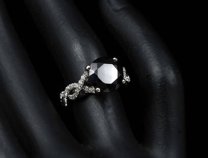 4.78 CT. BLACK DIAMOND SOLITAIRE RING: 4.78 CT. BLACK DIAMOND SOLITAIRE RING: This magnificent 18K white gold ring contains one 4.78 Ct round brilliant cut natural black diamond in a four-prong setting in a twist unity style ring with 68