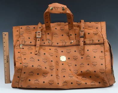 MCM VISETOS LOGOGRAM GARMENT BAG: MCM VISETOS LOGOGRAM GARMENT BAG: MCM Visetos logogram garment cover leather brown. Bag Height: approximately 43.3". Bag Length: approximately 24.4". DISCLAIMER: This item from a smoker's estate and