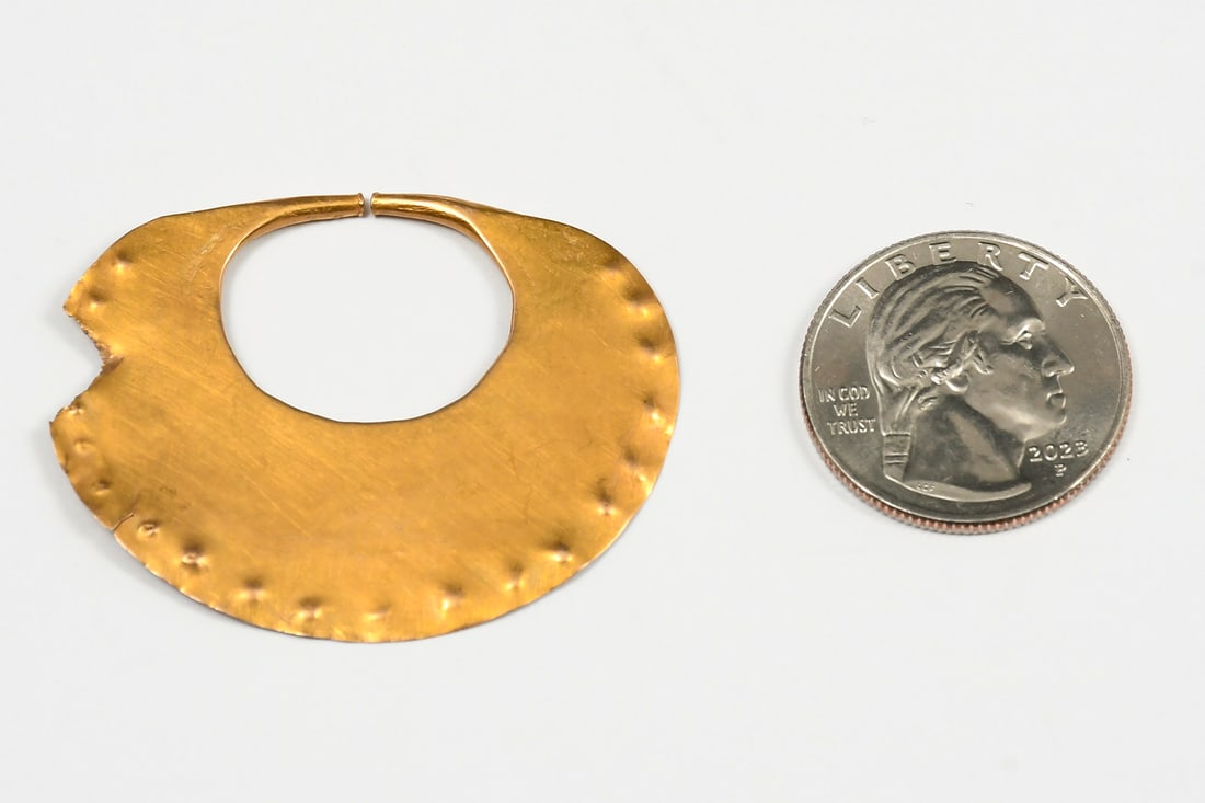 PRE-COLOMBIAN OR MOSHE 14K NOSE RING: PRE-COLOMBIAN OR MOSHE 14K NOSE RING: 14K yellow gold ovoid nose ring with primitive indented ornamentation. Possibly either pre-Colombian or Moshe. Approximate dimensions are 1.875" x 1.5". Weight: 5