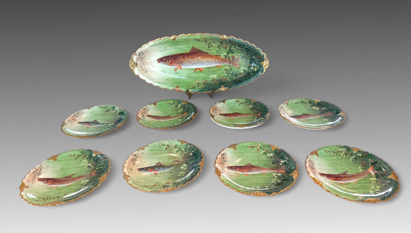 9 PC. FRENCH LIMOGES HAND PAINTED FISH SET: 9 PC. FRENCH LIMOGES HAND PAINTED FISH SET: Comprising; 1- Large Serving Platter and 6- Plates. All having hand-painted Fish on a green background with Gold Scalloped rims. All are signed by the artis