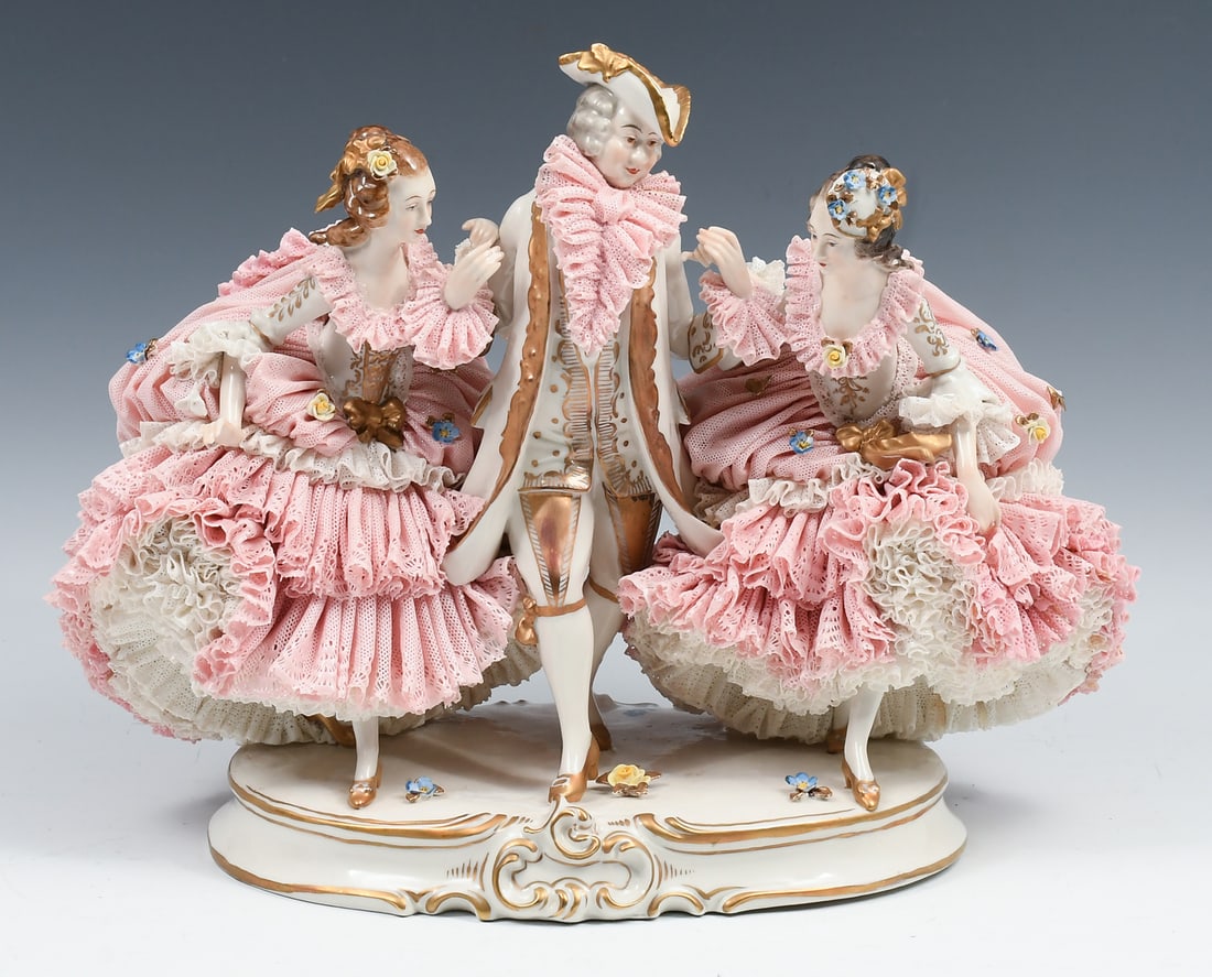 3 FIGURE GERMAN VOLKSTADT PORCELAIN GROUP W/ LACE: 3 FIGURE GERMAN VOLKSTADT PORCELAIN GROUP WITH LACE: Porcelain group sculpture of a dandy gentleman accompanied by two well-dressed ladies, with lace accents on all three. Measures 14.5" wide and 10.5