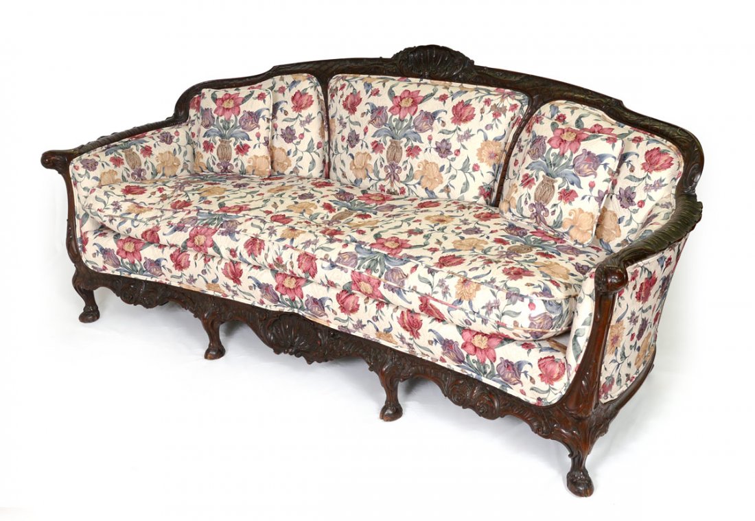 LATE 19TH CENTURY PROFUSELY CARVED MAHOGANY SOFA: LATE 19TH CENTURY PROFUSELY CARVED MAHOGANY SOFA: Ornate carved frame featuring shell, foliate, and floral motifs. 4 front legs end in hoof feet. Floral upholstery. 35 1/4" h. x 80" x 34".