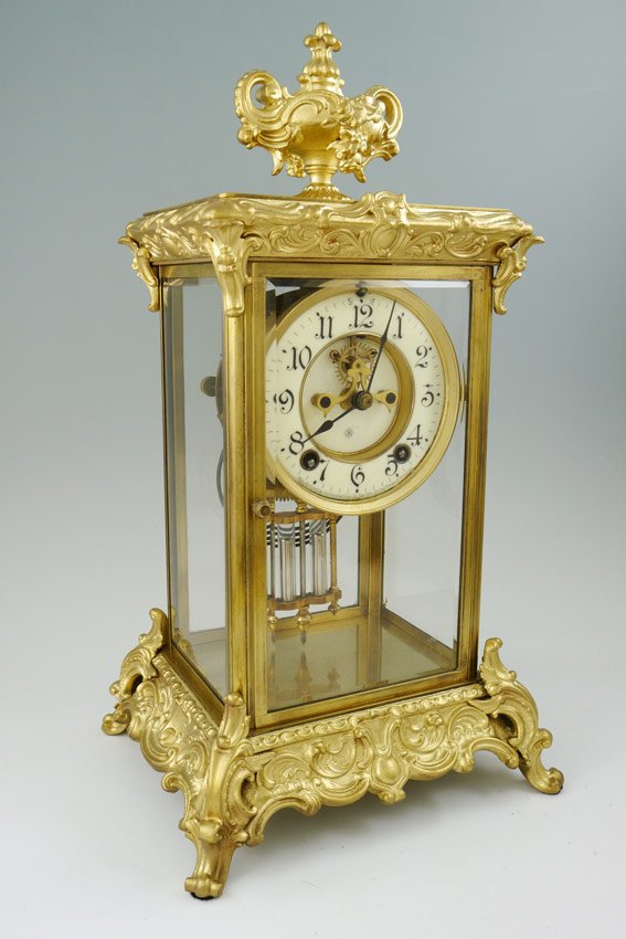 ANSONIA CROWN MODEL CRYSTAL REGULATOR CLOCK: ANSONIA ''CROWN'' MODEL CRYSTAL REGULATOR CLOCK: Ornate gilt brass case with urn finial, beveled glass panels. Open escapement on porcelain dial with Arabic numerals, marked Ansonia. 8 day time and st