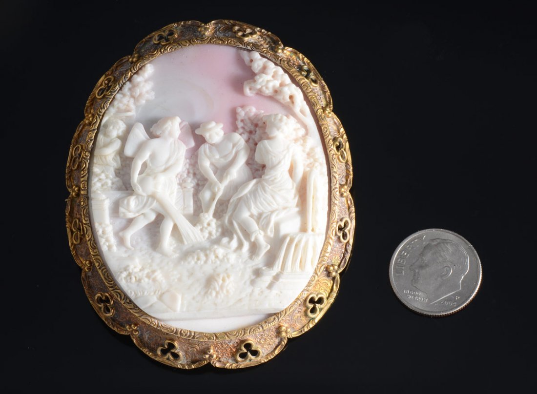 LARGE VICTORIAN CAMEO: LARGE VICTORIAN CAMEO: Shell carved cameo pin/ pendant set in 14K yellow gold. Picturesque scene with 3 figures. 2 1/4'' oval. Sold in the original presentation box. Mid 19th C.