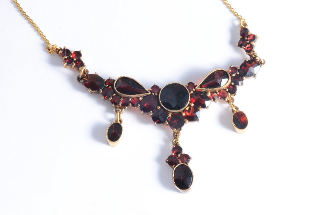 10 KT GOLD GARNET NECKLACE WITH RING: FANCY GARNET NECKLACE AND RING: 10K yellow gold necklace of approx. 33 round and pear faceted garnets, Bezel, bead and prong set. Length approx. 15". The ring has 17 garnets , size 5.