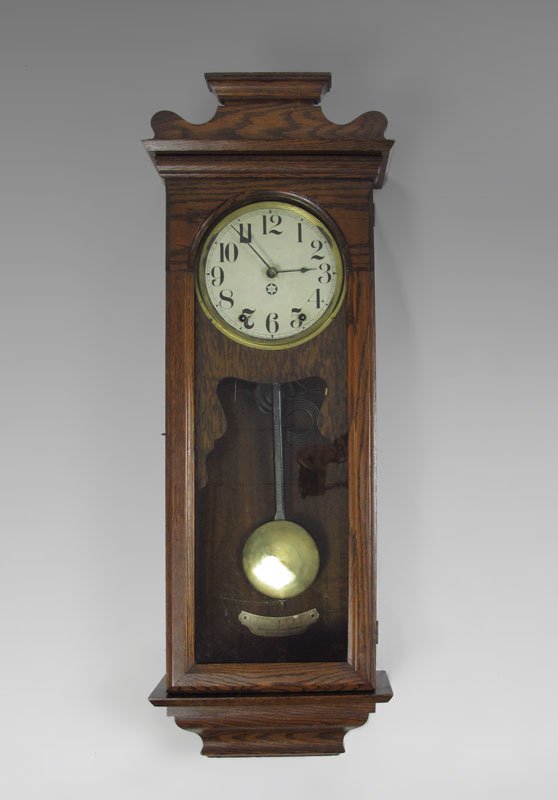 NEW HAVEN OAK CASED WALL CLOCK: NEW HAVEN OAK CASED WALL CLOCK: Oak case, paper over metal dial marked New Haven in star. Key & pendulum in office. 37'' h. x 13 1/2'' x 6 1/4''.