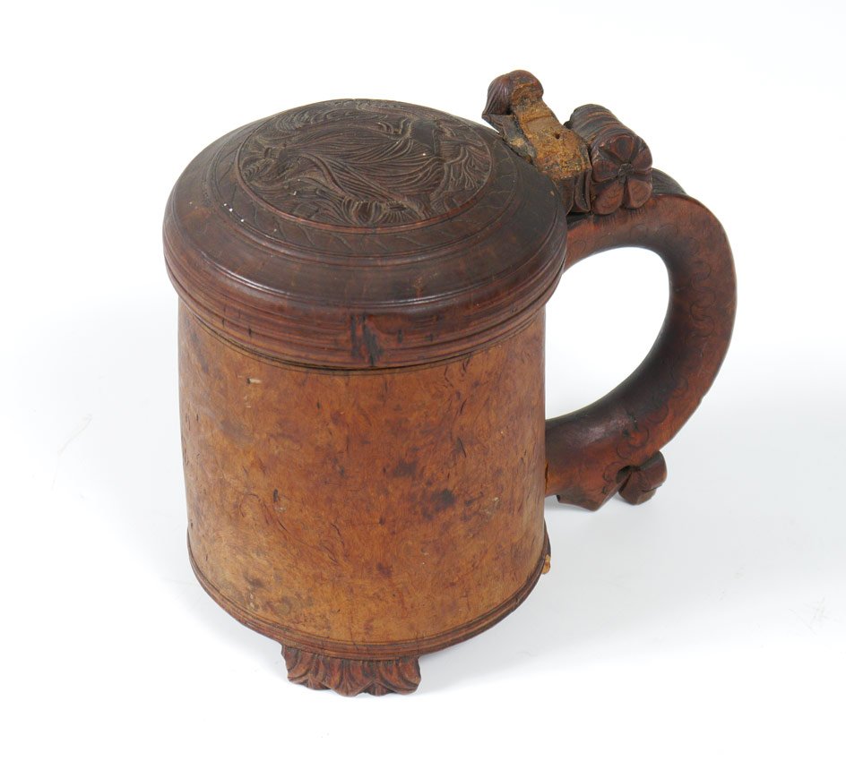 SCANDINAVIAN CARVED BURL WOOD STEIN: SCANDINAVIAN CARVED BURL WOOD STEIN: Carved hinged lid with figural lion motif, shaped burl body, 3 carved feet. Pegged handle, missing thumb press and lower peg. 6 1/2" h. x 7 1/4".