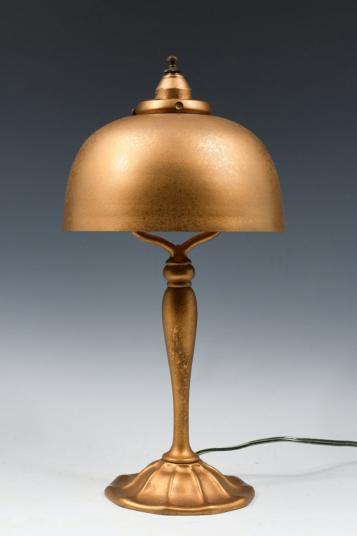 LOUIS COMFORT TIFFANY FURNACES DORE DESK LAMP: LOUIS COMFORT TIFFANY FURNACES DORE DESK LAMP: Early Tiffany Furnaces Dore Bronze lamp base, #16A. Married with a Dore metal shade with a spurious Tiffany 1414 stamp. Approx. 14.625" h x 7.375" dia.
