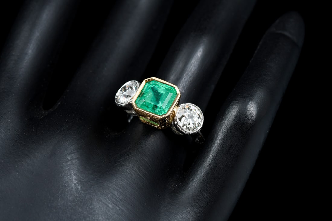 PLATINUM, 18K, EMERALD & DIAMOND RING: PLATINUM, 18K, EMERALD & DIAMOND RING: This magnificent platinum and 18K yellow gold ring contains one emerald cut emerald weighing approximately 3.30 Ct. Two old European round cut diamonds rated VS1
