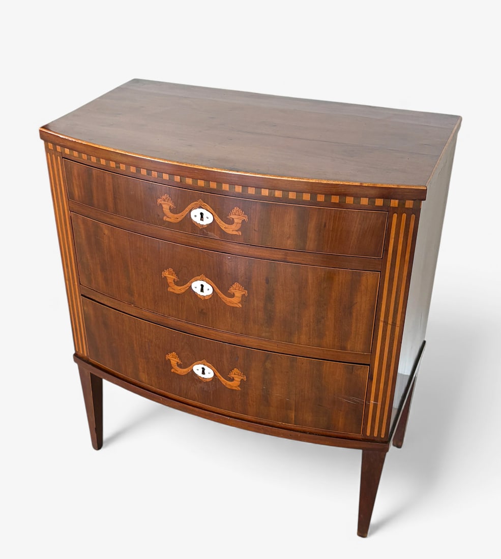 INLAID SWELL FRONT 3-DRAWER CHEST: INLAID SWELL FRONT 3-DRAWER CHEST: 3- Drawer chest with inlaid Cornucopia and Mother of Pearl Keyhole covers. Extra Keyhole cover is present. Raised on tapered square legs. Approx. 30.75" h x 26.5" w 