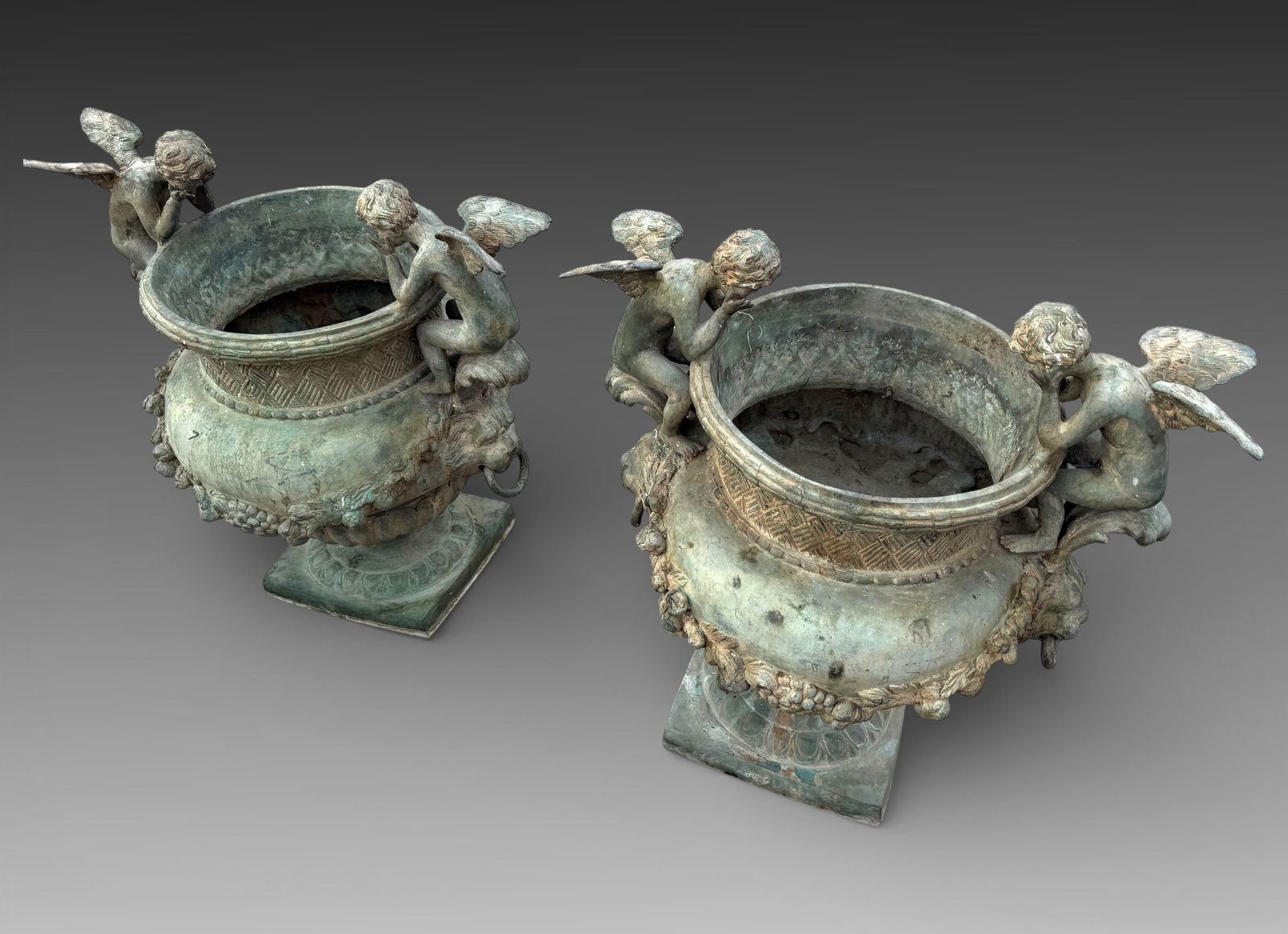PAIR OF BRONZE CHERUBIC GARDEN JARDINIERES: PAIR OF BRONZE CHERUBIC GARDEN JARDINIERES: 27.25" h. x 25.25".