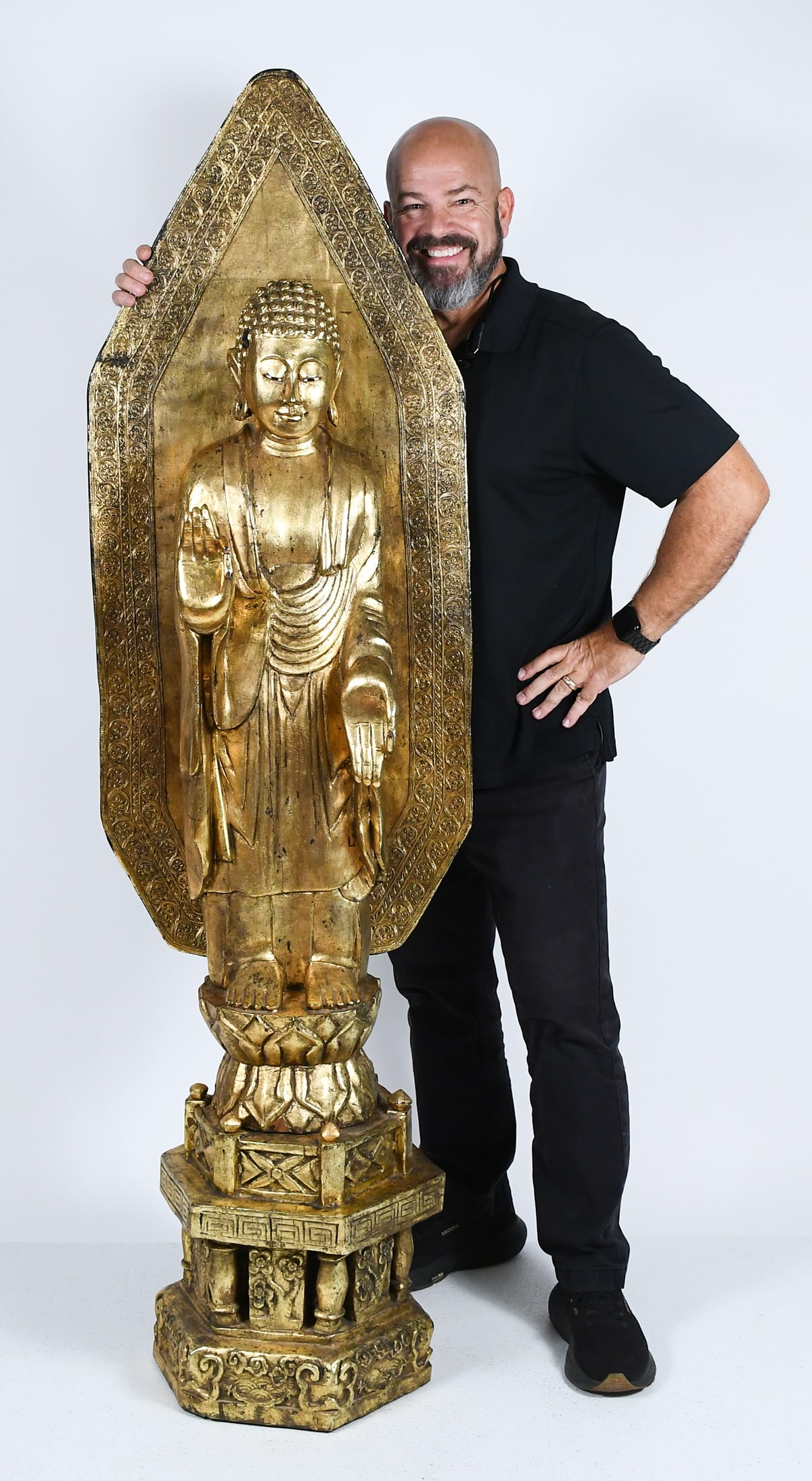 CARVED AND GILDED BUDDHA: NEAR LIFE-SIZE CARVED & GILT WOOD BUDDHA: An extensively Carved & Gilt wood Buddha with Abhaya Mudra hand pose (a gesture of fearlessness and granting protection). Mounted on a base with stylized Wave
