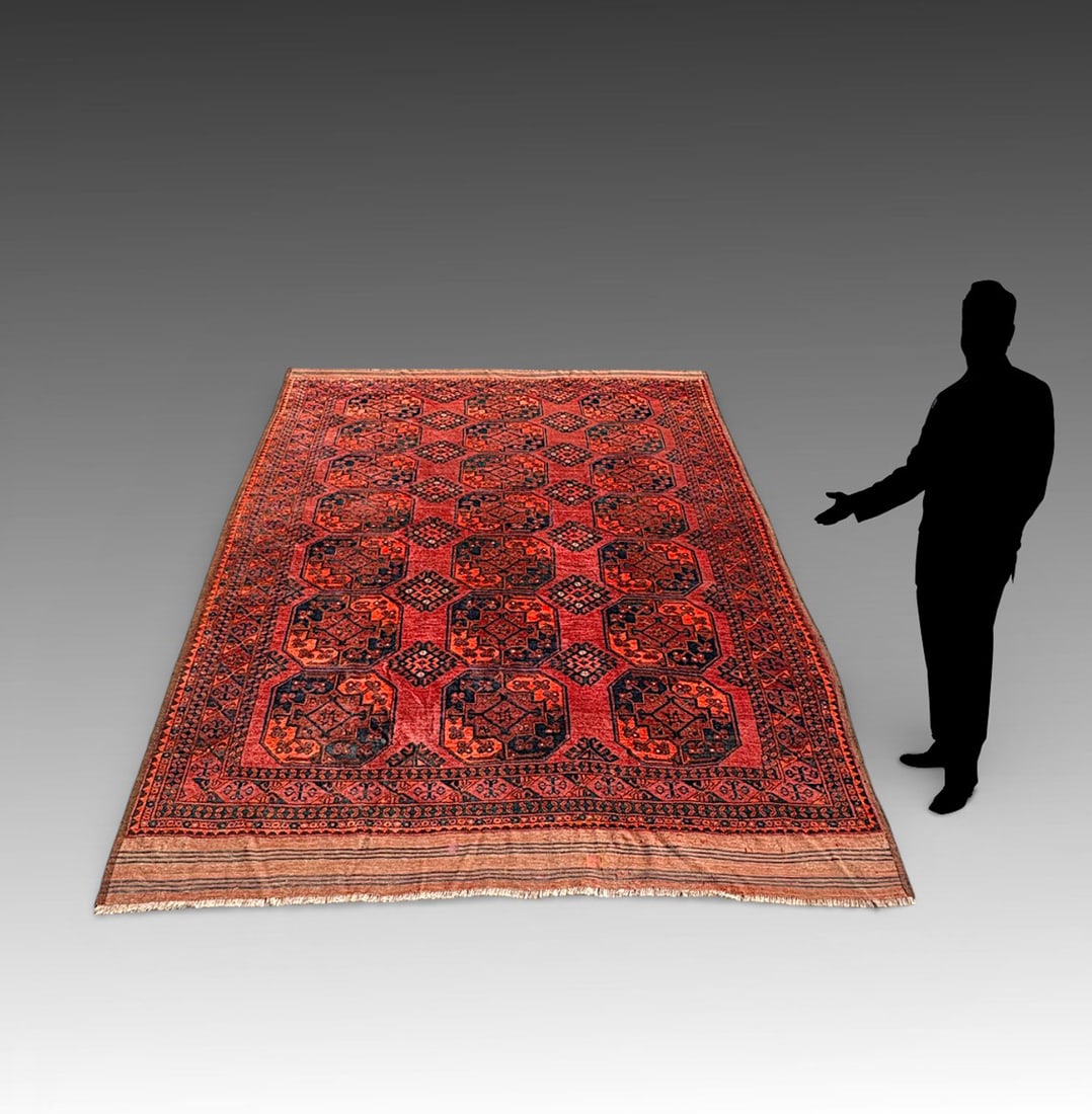 ANTIQUE AFGHAN TURKMEN (ERSARI-TYPE) DESIGN RUG: ANTIQUE AFGHAN TURKMEN (ERSARI-TYPE) DESIGN WOOL RUG: The field is composed of bold, repeating octagonal guls arranged in formal rows across a saturated madder red ground, enriched with deep indigo an
