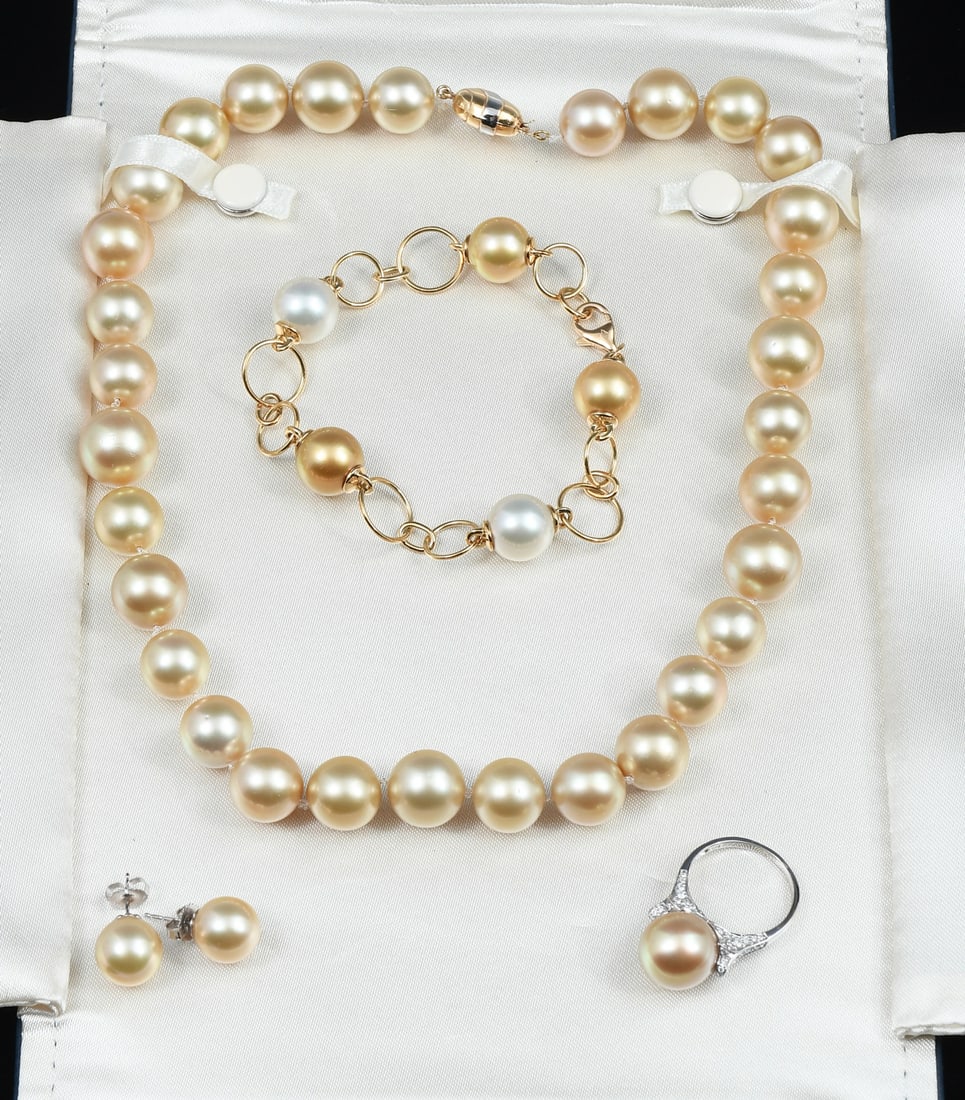 GOLDEN PEARL PARURE: GOLDEN PEARL PARURE: A parure of golden pearls to include a strand of cultured golden pearls measure 12-14 mm. Gold in color, slightly blemished, high luster. Length: 18". Origin of pearls is unknown.