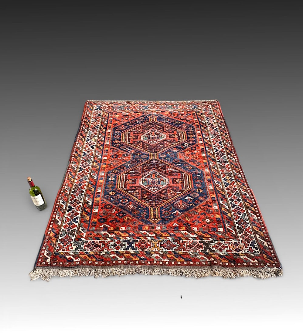 ANTIQUE PERSIAN KURDISH DESIGN WOOL RUG: ANTIQUE PERSIAN KURDISH DESIGN WOOL RUG: Antique Persian Kurdish wool rug featuring two stacked hexagonal medallions aligned on a richly patterned field of deep indigo and madder red, accented with ea