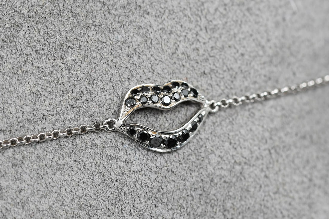 18K GOLD STEFERE DIAMOND LIPS BRACELET: 18K GOLD STEFERE DIAMOND LIPS BRACELET: 18K white gold bracelet contains 20 round brilliant cut black diamonds. WEIGHT: .12 Ct. Approx. The diamonds are prong set. Lobster claw clasp. Length: 7". Sign