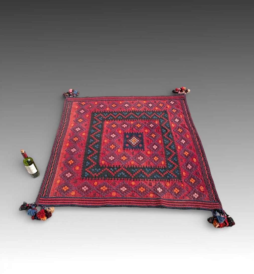 ANTIQUE AFGHAN KILIM FLATWEAVE WALL HANGING: ANTIQUE AFGHAN KILIM FLATWEAVE WALL HANGING: Antique Afghan kilim flatweave wall hanging, early 20th century. Square-format wool textile woven in a rich madder-red ground with indigo and saffron accen