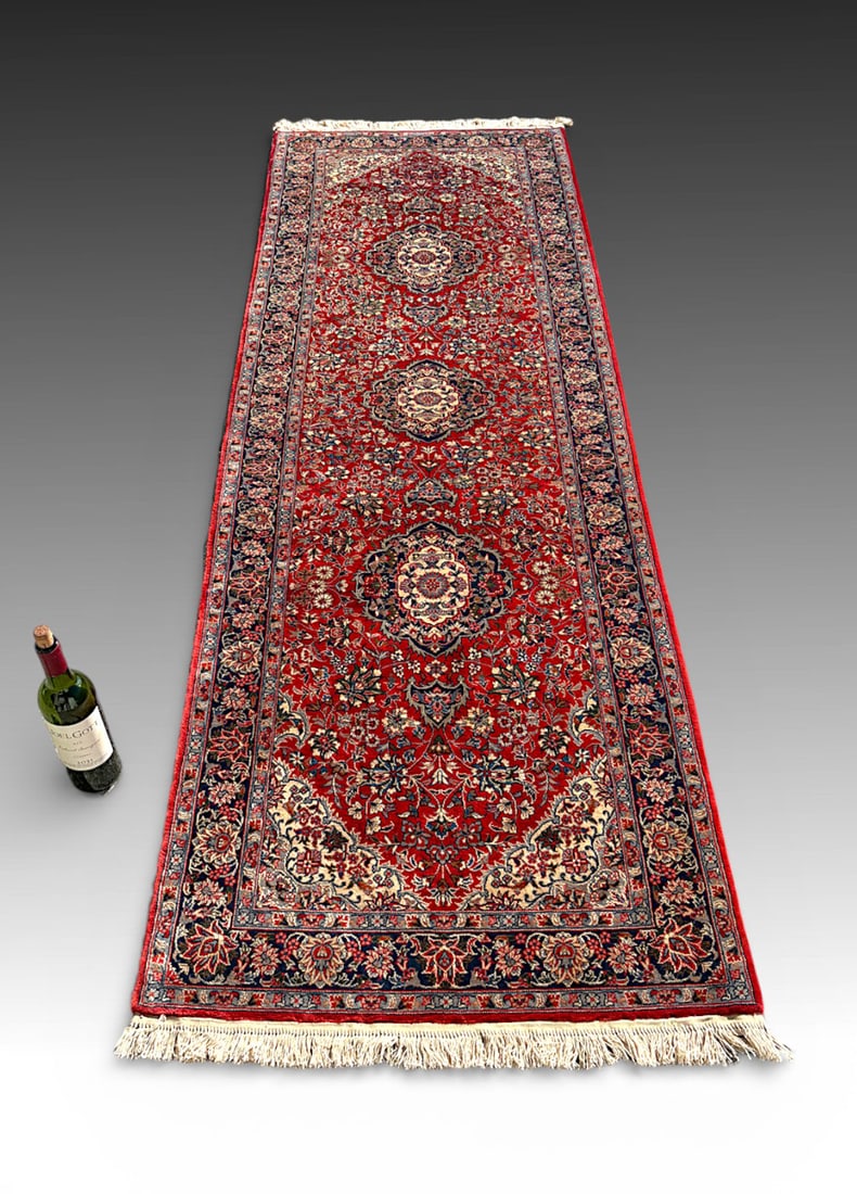 ANTIQUE CENTRAL PERSIAN SAROUK-TYPE WOOL RUNNER: ANTIQUE CENTRAL PERSIAN SAROUK-TYPE WOOL RUNNER: Finely woven rug with an elongated field centered by a series of finely drawn floral medallions arranged along the central axis, set against a rich mad