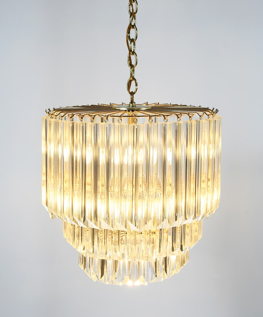 VINTAGE LUCITE ACRYLIC 11-LIGHT CHANDELIER: VINTAGE LUCITE ACRYLIC 11-LIGHT CHANDELIER: 11- Light, 3- tiered, gold toned metal frame with graduated triangular acrylic prisms. Approx. 32.5" h x 18.75" dia.