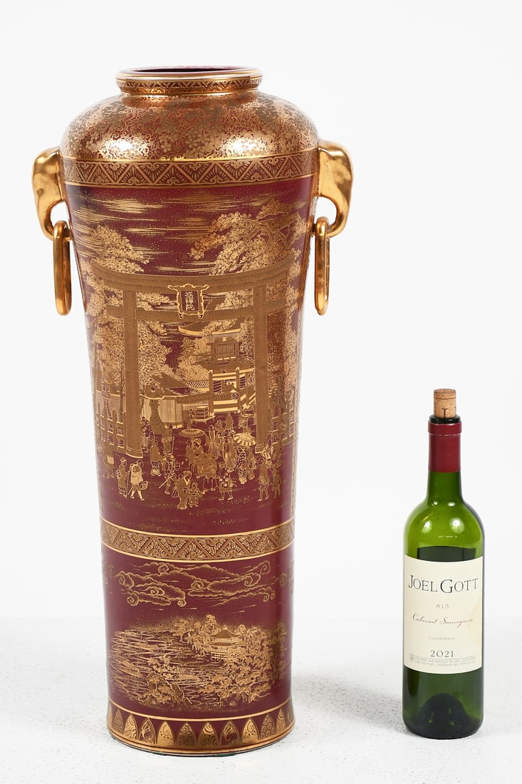TALL CHINESE PORCELAIN GILT FIGURAL VASE: TALL CHINESE PORCELAIN GILT FIGURAL VASE: A Merlot colored ground with festive Gilt figural Palace scenes and traditional designs. Elephant handles with rings. Approx. 24.625" h x 11.625" w x 9.45" d.