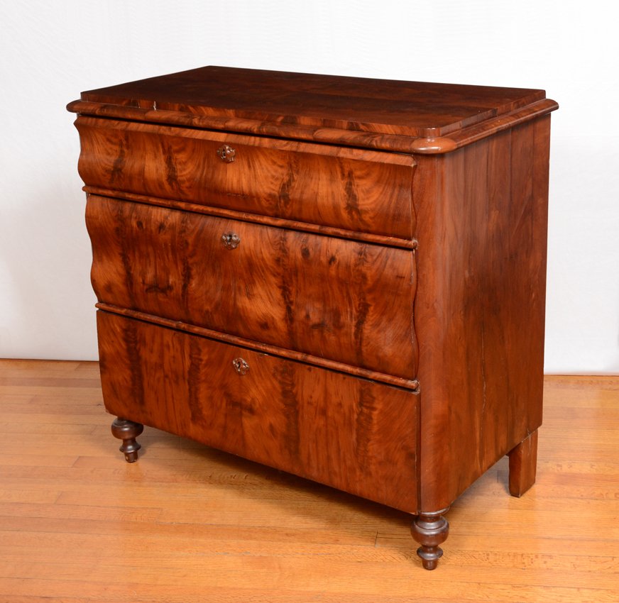 BIEDERMEIER FLAME GRAIN MAHOGANY 3 DRAWER CHEST: BIEDERMEIER FLAME GRAIN MAHOGANY 3 DRAWER CHEST: Richly grained mahogany veneer. 3 shaped graduating drawers with carved wood escutcheons, turned front legs. 36" h. x 38 3/4" x 19 1/4".