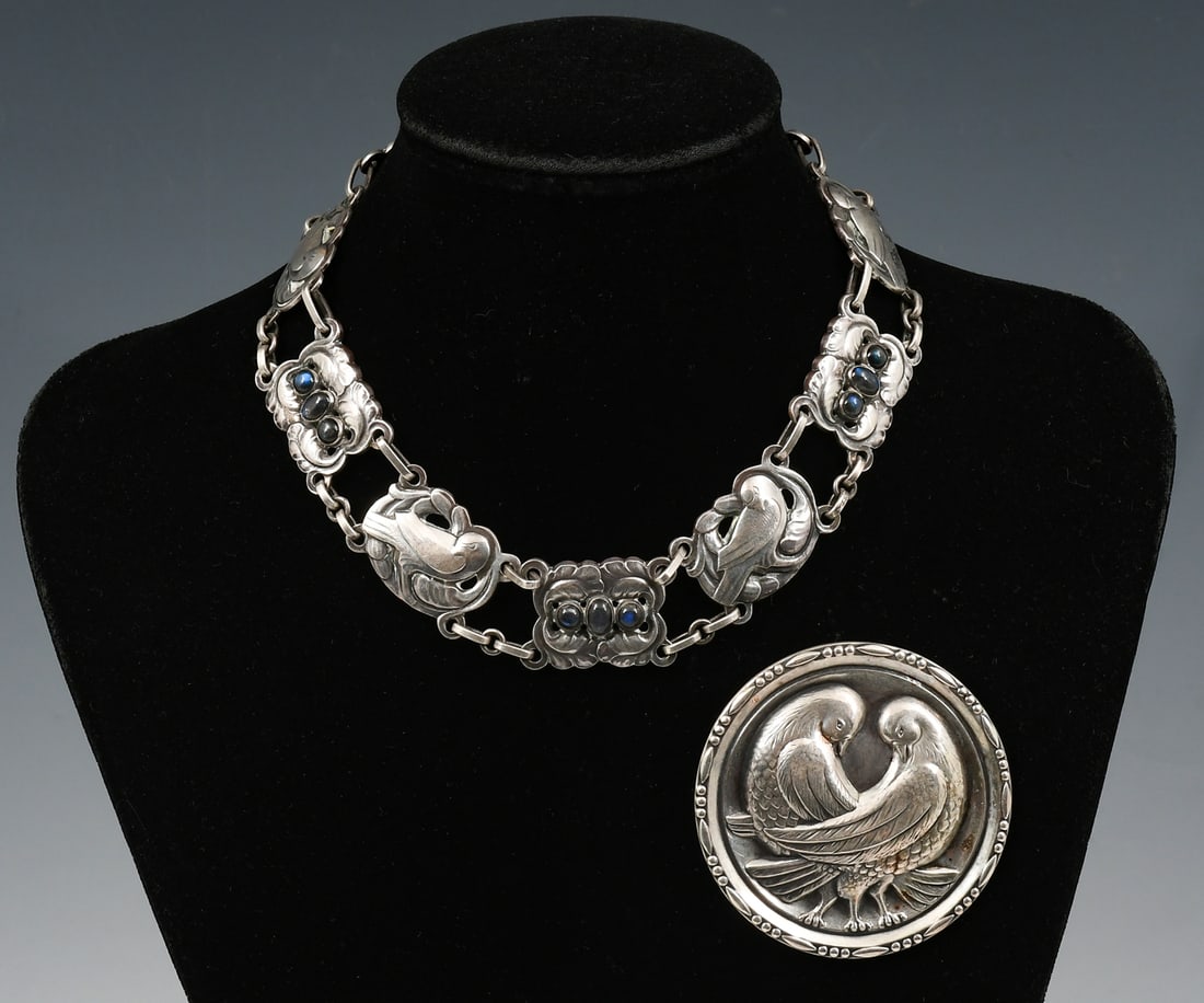 2PC. GEORG JENSEN BROOCH & NECKLACE SUITE: 2PC. GEORG JENSEN BROOCH & NECKLACE SUITE:A stunning sterling George Jensen suite of a necklace and brooch. Approximately 2.25" in diameter The repousse brooch features two interlocking doves, The