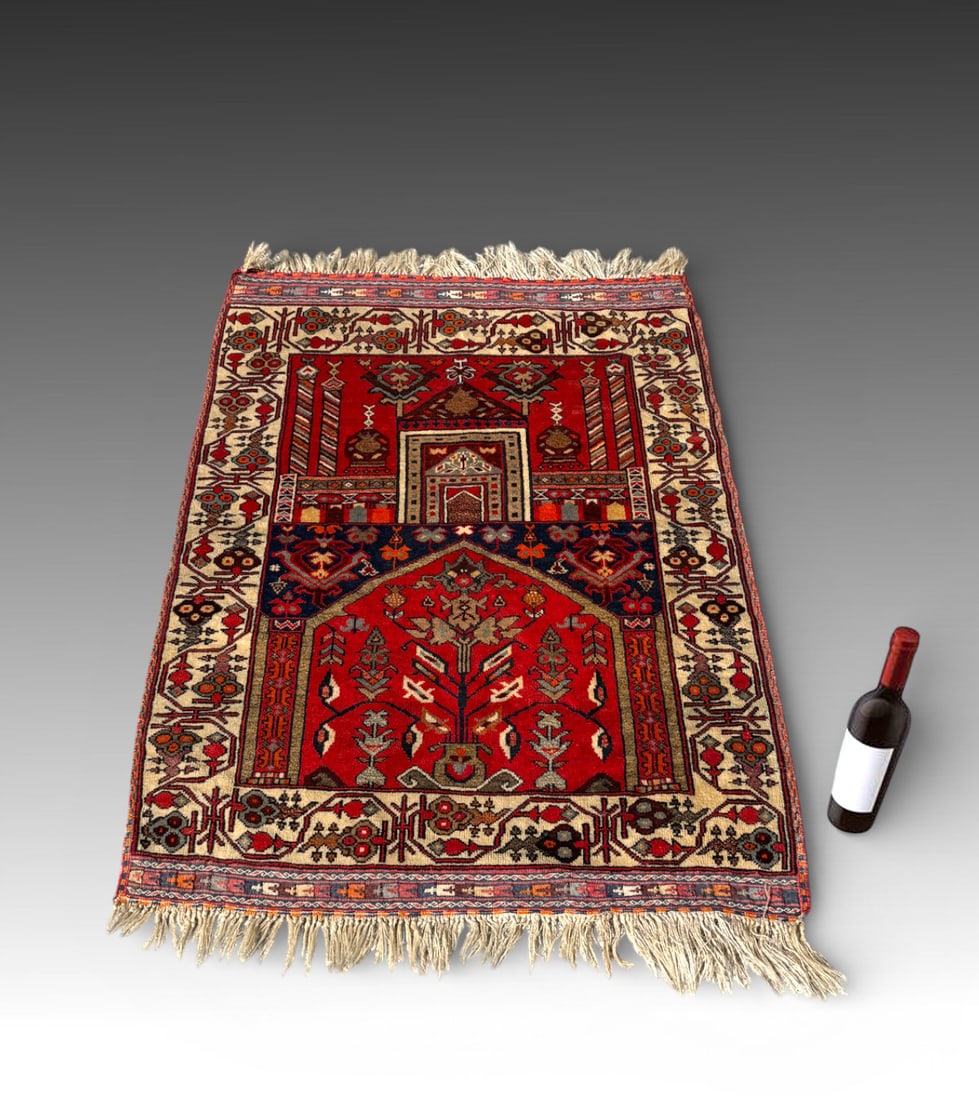 ANTIQUE KARABAGH DESIGN PRAYER RUG: ANTIQUE KARABAGH DESIGN PRAYER RUG: Southern Caucasus, late 19th century. Featuring an architectural mihrab with stylized symbolic motifs above a bold red field with a tribal tree-of-life design,