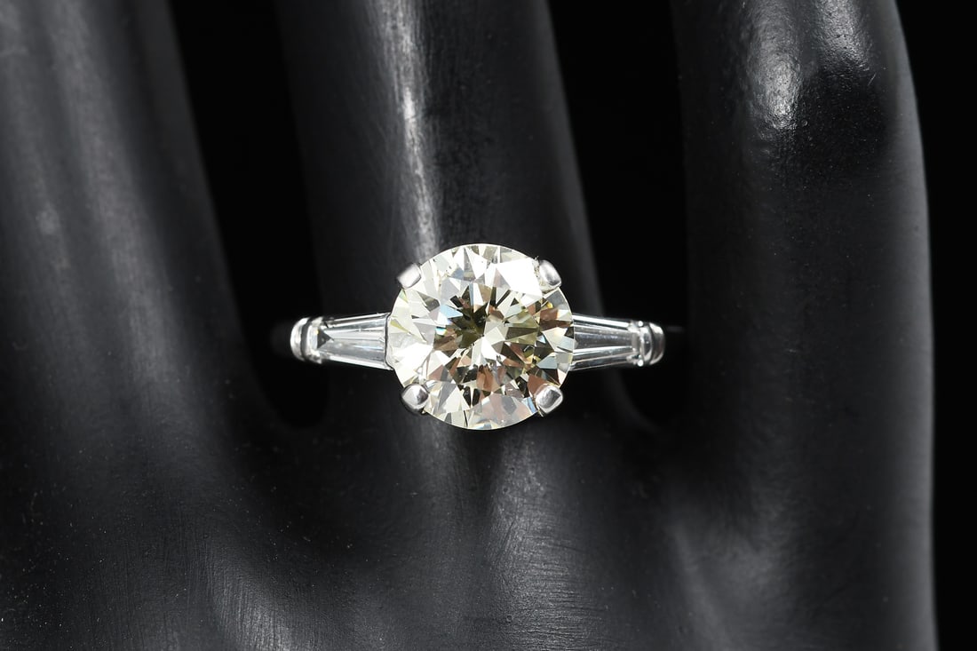 PLATINUM 2.04CT DIAMOND SOLITAIRE RING: PLATINUM 3CTW DIAMOND RING: A vintage solitaire platinum diamond ring with 2.75 Ct center stone and flanked with 2 tapered baguette diamonds. Total diamond weight: 3 CTW. Ring size: 8. Weight: 5.3 gra